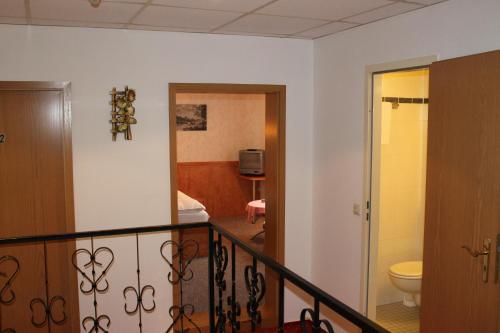 a room with a balcony with a bathroom and a toilet at Gasthaus& Pension Zum Roten Haus in Bad Schandau