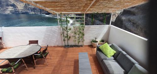 balcón con mesa y sofá en un barco en Penthouse de Roca in Poblado Marinero en Santiago del Teide