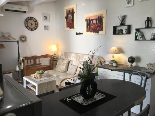 een woonkamer met een tafel en een bank bij Bastidon des Alpilles 11 in Saint-Rémy-de-Provence