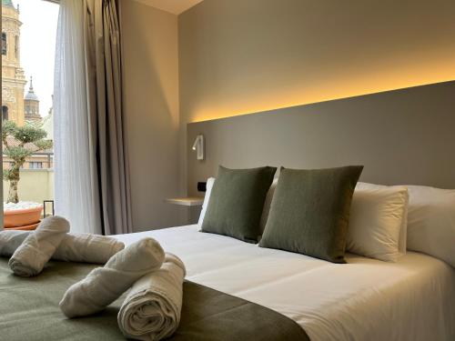 a bedroom with a large white bed with a window at VTZ Hotel San Valero in Zaragoza
