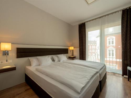 ein Schlafzimmer mit einem großen Bett und einem großen Fenster in der Unterkunft Hotel Nordhausen in Nordhausen