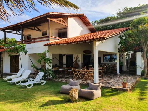 una casa con patio y sillas en el patio en ITACUPA - Healthy VEGAN & FOIL Center, en Cumbuco