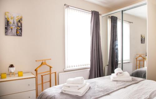 a bedroom with white towels on a bed with a mirror at Contractor house, sleeps 5, close to restaurant's and bars, Long stays available, Oveyo Accommodation in Middlesbrough