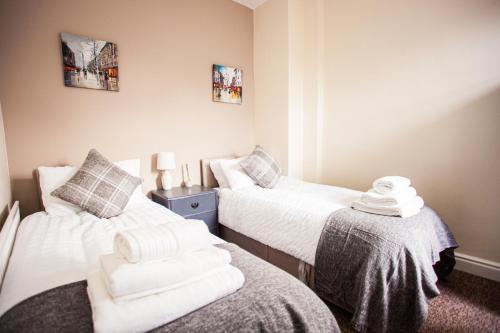 due letti in una piccola stanza con asciugamani sopra di Contractor house, sleeps 5, close to restaurant's and bars, Long stays available, Oveyo Accommodation a Middlesbrough