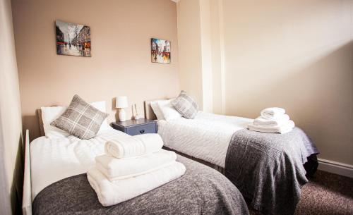 two beds in a room with towels on the bed at Contractor house, sleeps 5, close to restaurant's and bars, Long stays available, Oveyo Accommodation in Middlesbrough