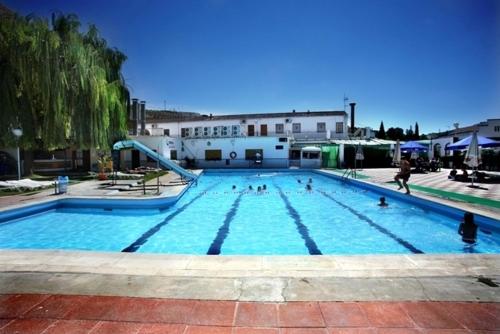 una gran piscina azul con gente en ella en Hotel La Moraleda - Complejo Las Delicias, en Villanueva del Arzobispo