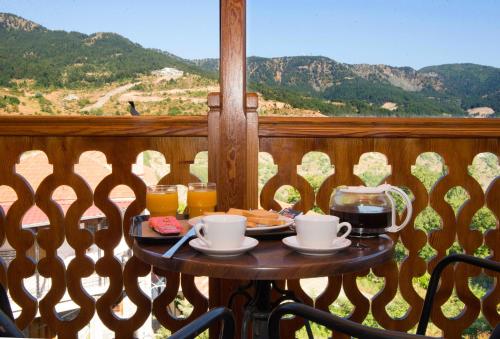 a table on a balcony with a tray of food and drinks at La Petri Studios with Fireplace & View in Metsovo