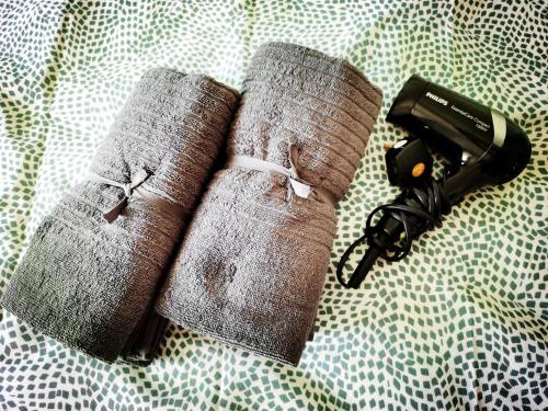 two rolled up towels on a bed next to a flashlight at TuR11-Oppesite Pisa Stadium-1min-FoodCourt-MiniMarket in Bayan Lepas