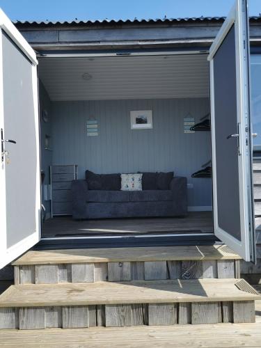 a living room with a couch in a garage at Allibella Shepherds Hut, Amazing Seaview, Private garden, Pet Friendly in Barmouth