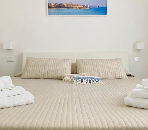 - un grand lit avec deux oreillers et une table dans l'établissement La dimora di Clara, à Trapani