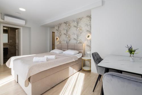 um quarto branco com uma cama grande e uma mesa em HARMONY Stay APARTAMENTAI su terasa ir vaizdu į miestą em Telšiai