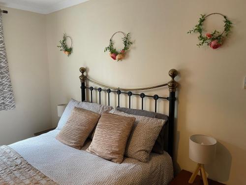 a bedroom with a bed with pillows and plants on the wall at Craigavon Cottage in Ballachulish