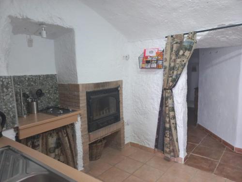 een woonkamer met een open haard in een kamer bij Cuevas Barrio Las Santas in Huéscar