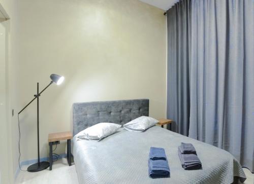 a bedroom with a bed with two towels on it at Pasta Amber Lux in Liepāja