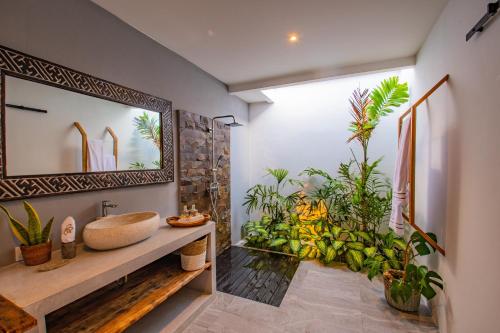 Un baño con lavabo y algunas plantas. en Hedonia Luxury Villas, en Seminyak