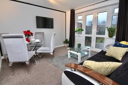 a living room with a couch and a table at Daimler House - Cosy Home Near Coventry City Centre in Coventry