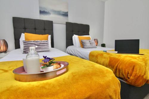 two beds with a plate of food and a bottle of milk at Daimler House - Cosy Home Near Coventry City Centre in Coventry