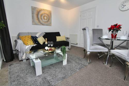 a living room with a couch and a table at Daimler House - Cosy Home Near Coventry City Centre in Coventry