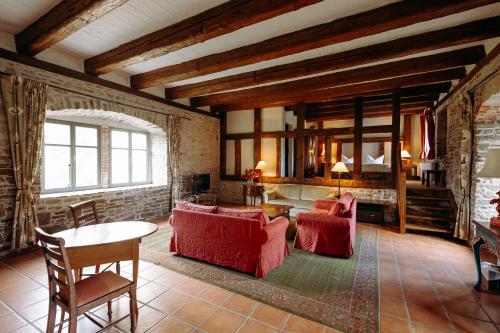 a living room with red chairs and a table at Hotel Burg Wanzleben in Wanzleben