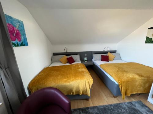 een slaapkamer met 2 bedden en een stoel bij Strandnest Büsum Ferienhaus in Büsumer Deichhausen