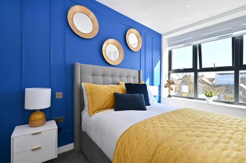 ein blaues Schlafzimmer mit einem Bett und Spiegeln an der Wand in der Unterkunft Spacious Designer 2BR Executive Apt, Near Beach & Marina, Central Location in Kent