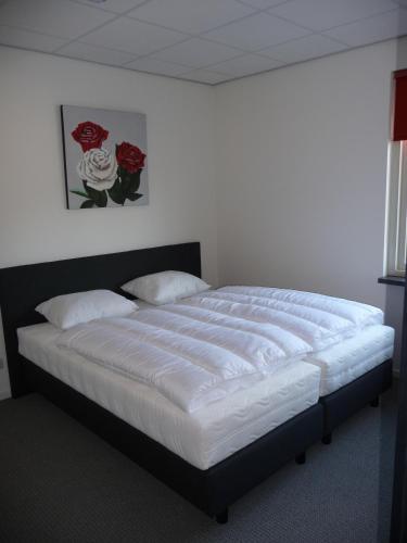 a bedroom with a large bed with white sheets at Apartment Nieuw-Moscou in Hollandscheveld