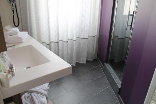 a bathroom with a sink and a shower at Hôtel François Premier Cognac Centre in Cognac