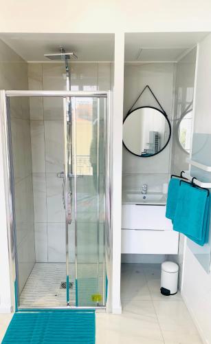 een badkamer met een douche, een wastafel en een spiegel bij Villa cadette, à 200m de monaco in Beausoleil