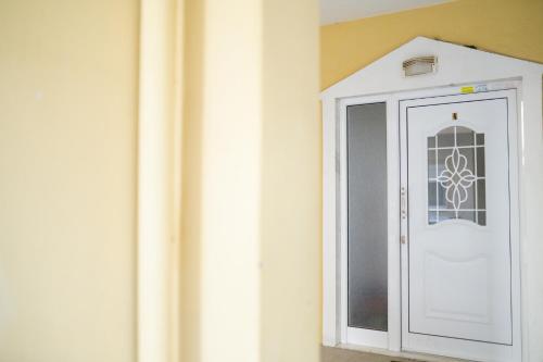 a white door with a window on a wall at One Bedroom Flat 300m from Sea in Alexandroupoli
