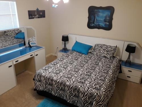 a bedroom with a bed and a desk with a mirror at Large Modern Residence with private guest, family room & business office in Missouri City