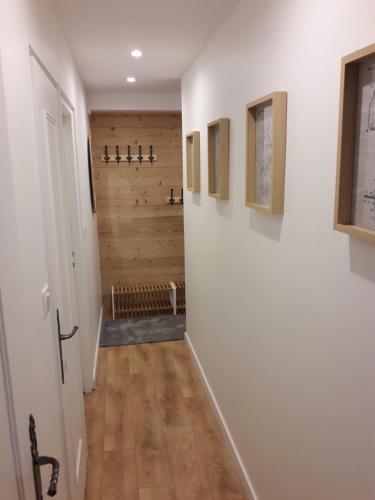 un couloir avec des murs blancs et un mur en bois dans l'établissement Le Paradis du Diable 6 pers 40m2 pied des pistes et du télésiège du diable, à Les Deux Alpes