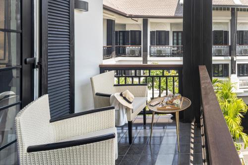 a balcony with two chairs and a table at Buri Sriping Riverside Resort & Spa in Chiang Mai