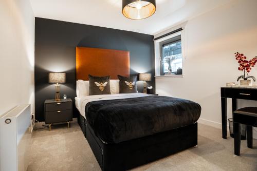 um quarto com uma cama preta e uma secretária em The Arran Suite - Your Stylish Scottish Getaway! em Glasgow