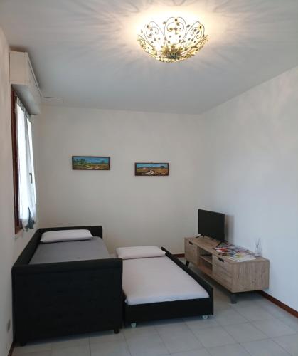 a room with two beds and a chandelier at Appartamento La Libellula in Grosseto