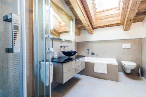 a bathroom with a sink and a toilet and a window at Matthiol Appartements in Zermatt