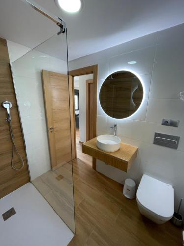 a bathroom with a toilet and a sink and a mirror at Apartamentos - Casa El Ancla in Celorio