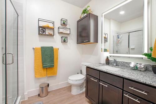 a bathroom with a toilet and a sink and a mirror at Luxury Studio near DT Fort Worth in Fort Worth