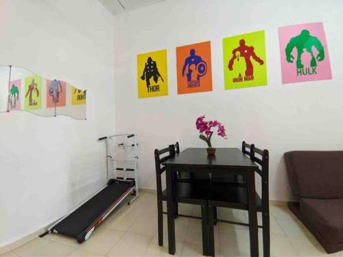 a room with a table and posters on the wall at HOMESTAY DELISHA PARIT RAJA UTHM in Parit Raja