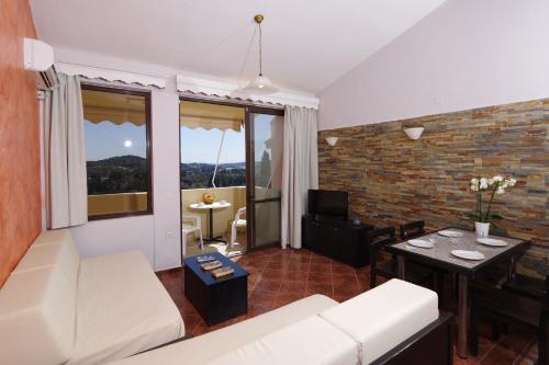 a living room with a couch and a table at Penelope Apartment Hotel in Dassia