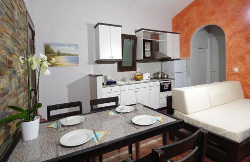 a kitchen and living room with a table and a couch at Penelope Apartment Hotel in Dassia