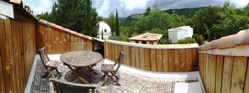 een patio met een tafel en stoelen en een hek bij Appartement T2 "Altaïr" de l'observatoire in Bauduen