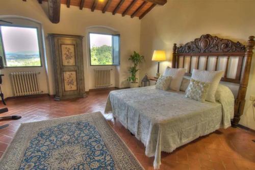 a bedroom with a large bed and two windows at Villa Selva in Lastra a Signa