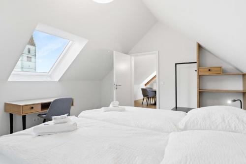 a bedroom with two beds and a desk and a window at Hotel Garni Traube in Friedrichshafen