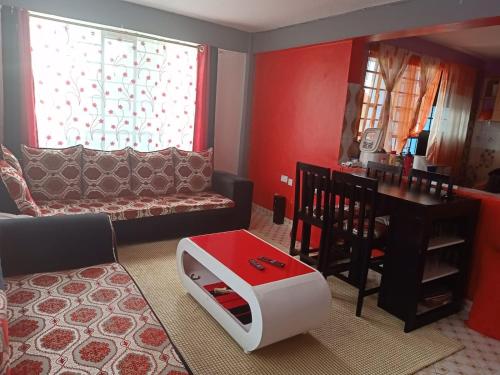 een woonkamer met een bank en een tafel bij Megs Place - Red - Embu Town in Embu