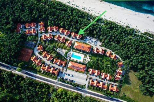 an aerial view of a house with a green arrow at Dom za Wydmą in Rogowo