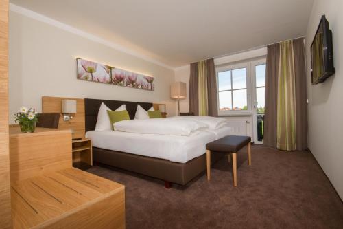 ein Hotelzimmer mit einem Bett und einem Fenster in der Unterkunft Hotel-Gasthof Beim Böckhiasl in Neukirchen an der Vöckla