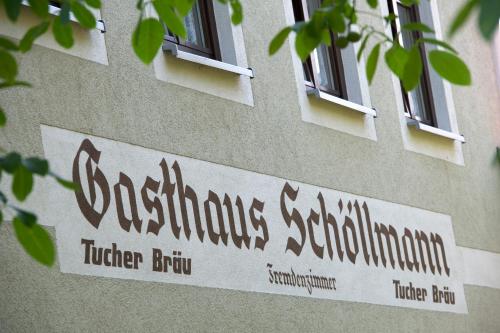a sign on the side of a building with windows at Gasthaus Schöllmann in Feuchtwangen