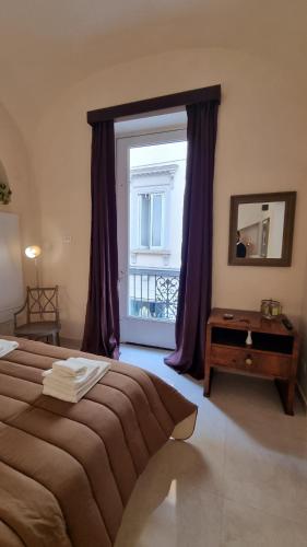 een slaapkamer met een groot raam met paarse gordijnen bij FERDINANDO HOME in Caserta
