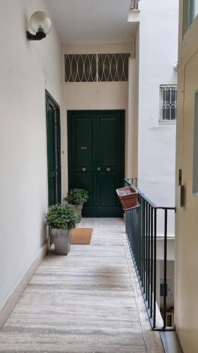 a hallway with a green door and two potted plants at FERDINANDO HOME in Caserta