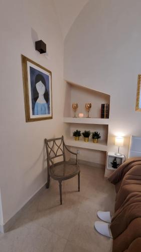a living room with a chair and a picture on the wall at FERDINANDO HOME in Caserta